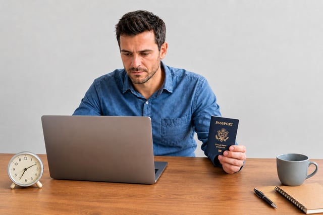 A Traveller Looking At A Laptop With A Passport