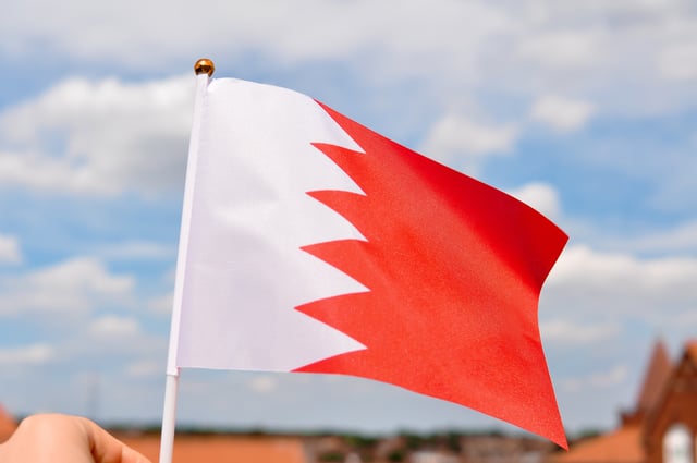 Image of a hand holding the Bahrain flag