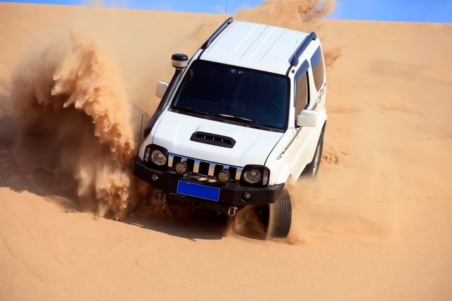 Suv Driving Through Desert Sand